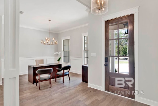 dining area with a chandelier, crown molding, and light hardwood / wood-style flooring