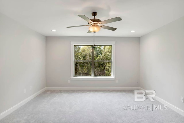 carpeted spare room featuring ceiling fan