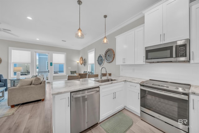 1592 W Beach Blvd, Gulf Shores, AL 36542 - kitchen with white cabinetry, sink, decorative light fixtures, kitchen peninsula, and stainless steel appliances