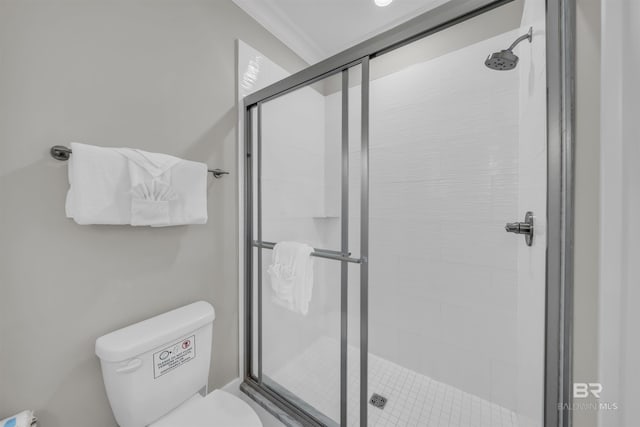 1592 W Beach Blvd, Gulf Shores, AL 36542 - bathroom featuring a shower with shower door, toilet, and ornamental molding