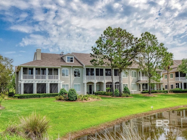 200 Peninsula Blvd Unit A202, Gulf Shores, AL 36542 - rear view of house featuring a chimney, a lawn, and stucco siding