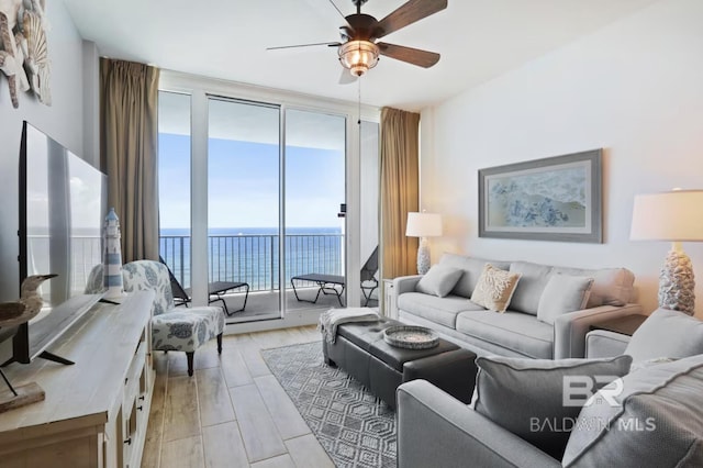 455 E Beach Blvd Unit 807, Gulf Shores, AL 36542 - living area featuring expansive windows, a water view, ceiling fan, and light wood-type flooring