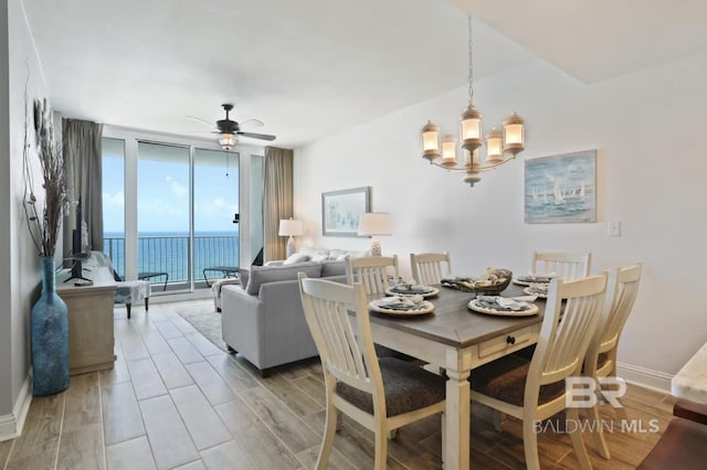 455 E Beach Blvd Unit 807, Gulf Shores, AL 36542 - dining space with expansive windows, a chandelier, a ceiling fan, a water view, and light wood-style flooring