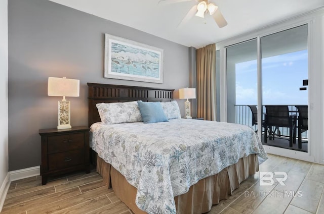 455 E Beach Blvd Unit 807, Gulf Shores, AL 36542 - bedroom featuring wood finish floors, access to exterior, baseboards, ceiling fan, and a wall of windows