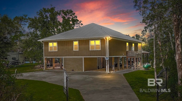 view of front of property with driveway, a lawn, and a carport