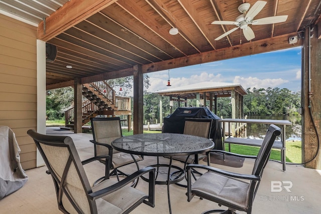 view of patio / terrace with stairs, outdoor dining space, and a ceiling fan