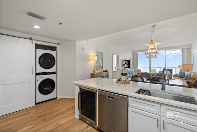 kitchen with wine cooler, sink, white cabinetry, stainless steel dishwasher, and stacked washing maching and dryer