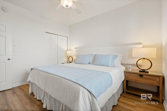 bedroom featuring ceiling fan, hardwood / wood-style floors, and a closet