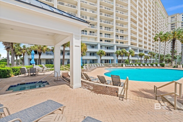 view of pool featuring a hot tub and a patio area