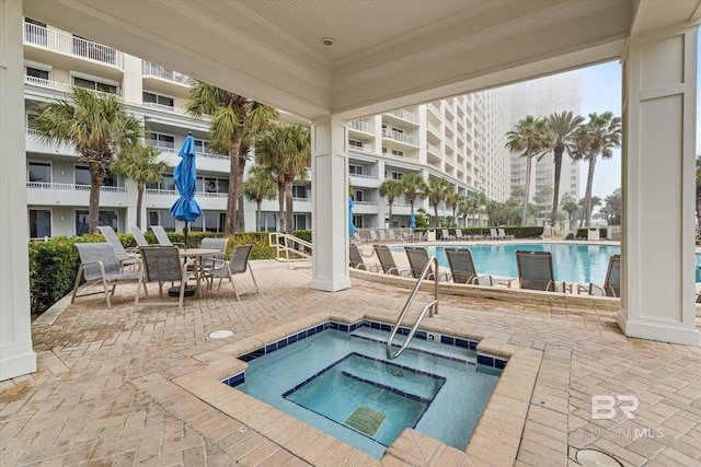 view of swimming pool featuring a patio and a community hot tub