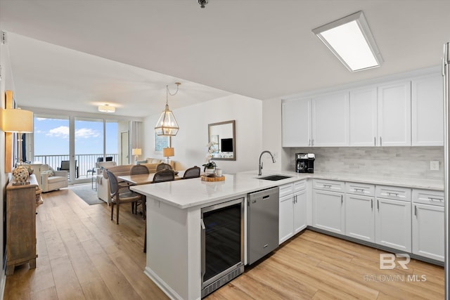 kitchen featuring wine cooler, sink, white cabinetry, and stainless steel dishwasher