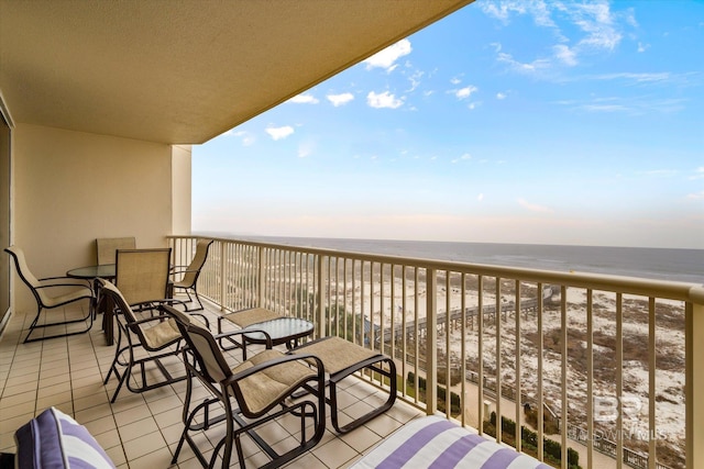 balcony with a water view and a view of the beach