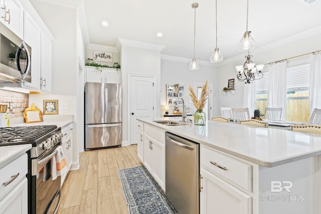 kitchen featuring an island with sink, stainless steel appliances, sink, white cabinetry, and light wood-type flooring