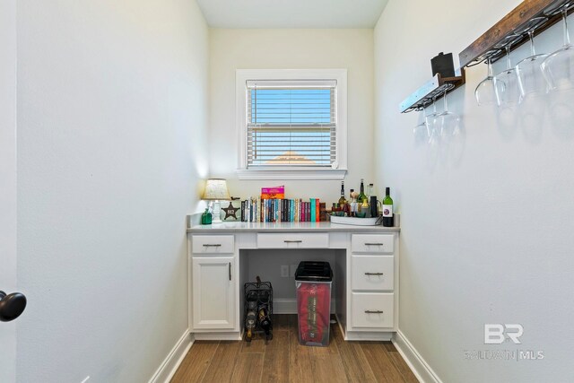 bar featuring white cabinets and light hardwood / wood-style flooring