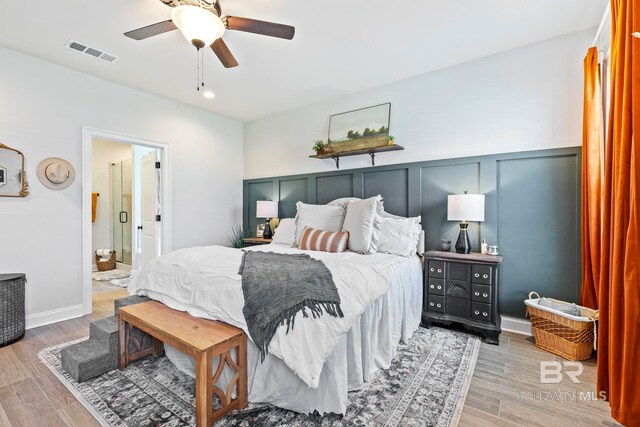 bedroom with wood-type flooring, ensuite bathroom, and ceiling fan