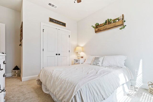 bedroom featuring a closet, ceiling fan, and light carpet