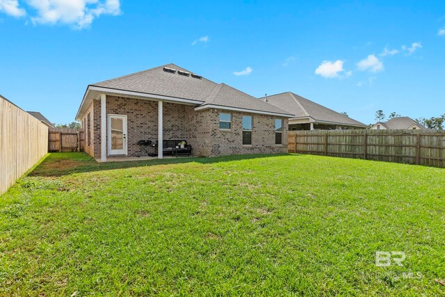 rear view of house with a yard and a patio