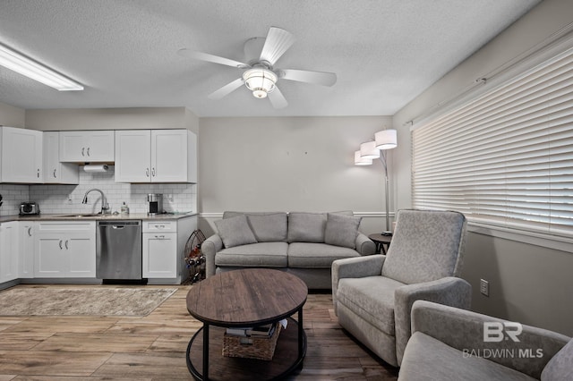 27222 Gulf Rd, Orange Beach, AL 36561 - living room featuring light wood-style flooring, a textured ceiling, and a ceiling fan
