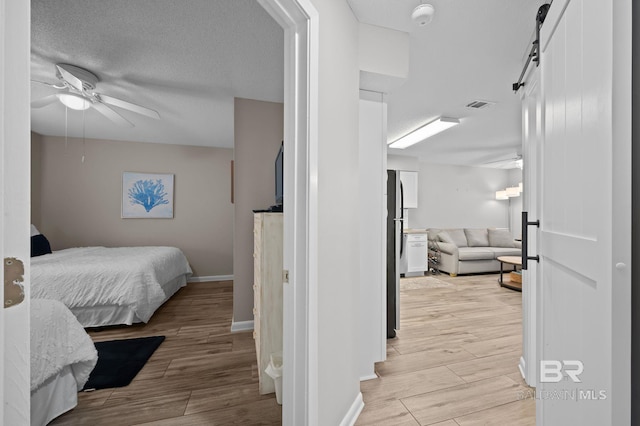 27222 Gulf Rd, Orange Beach, AL 36561 - bedroom with light wood-style floors, freestanding refrigerator, baseboards, and a barn door