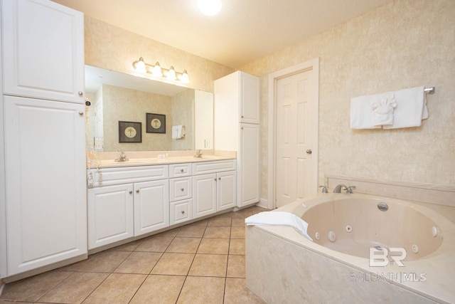 bathroom featuring tile patterned floors, vanity, a bath, and a textured ceiling