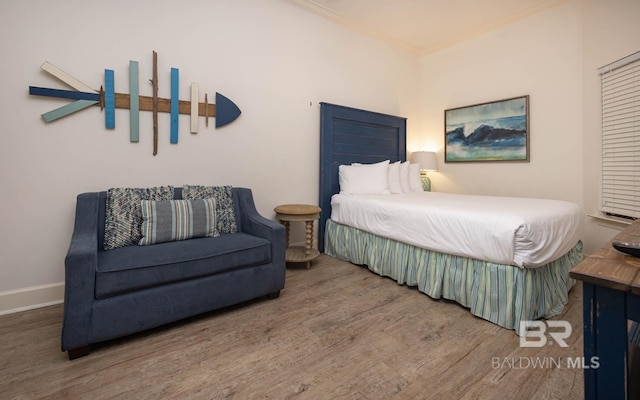 bedroom featuring hardwood / wood-style flooring and crown molding