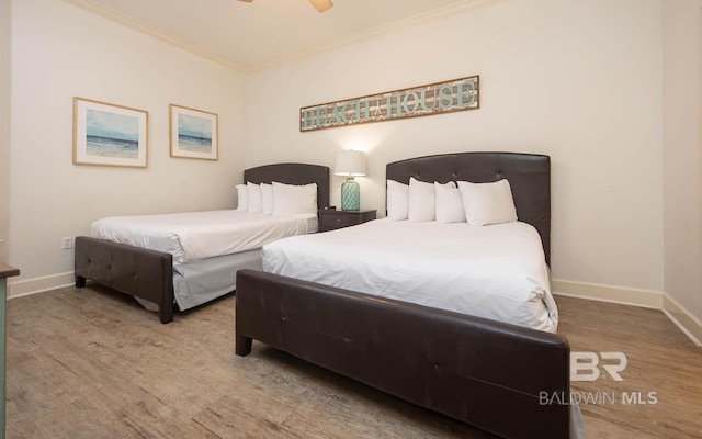 bedroom featuring ceiling fan, light wood-type flooring, and ornamental molding