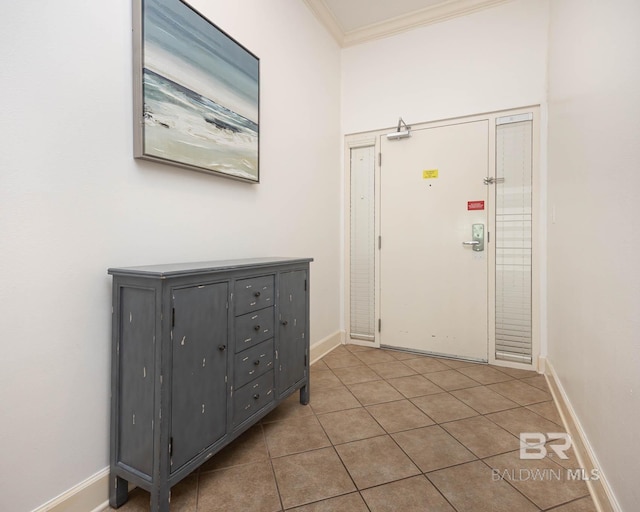 foyer with tile patterned floors and crown molding