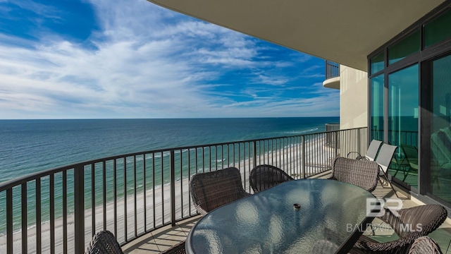 balcony with a water view and a view of the beach