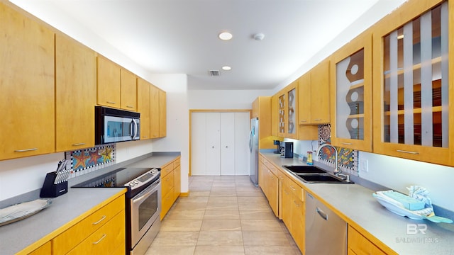 kitchen featuring appliances with stainless steel finishes, sink, and light tile floors