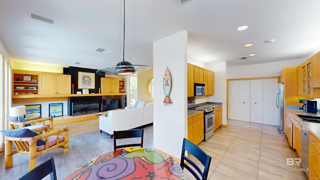 kitchen featuring hanging light fixtures, stainless steel appliances, sink, and light tile floors