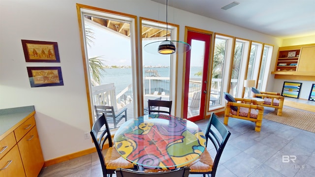 dining space featuring tile flooring and a water view