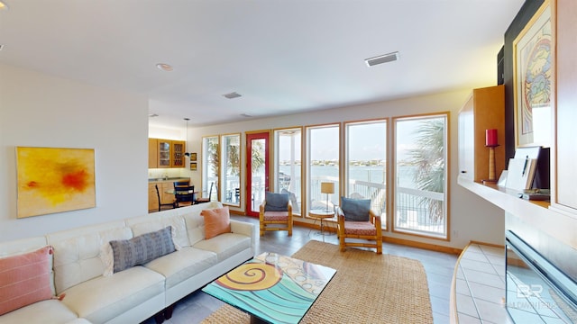 living room featuring a water view and tile flooring