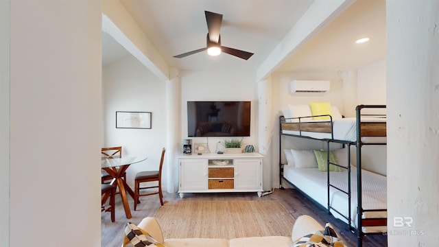 bedroom featuring a wall unit AC, ceiling fan, and light hardwood / wood-style flooring