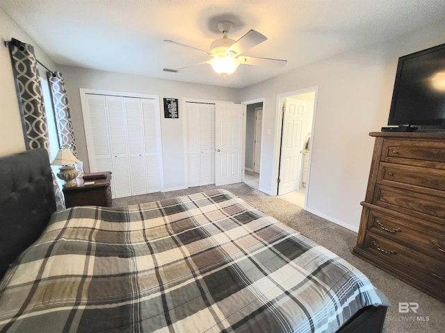 bedroom featuring carpet, two closets, and ceiling fan