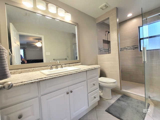 bathroom with tile patterned flooring, vanity, toilet, and ceiling fan