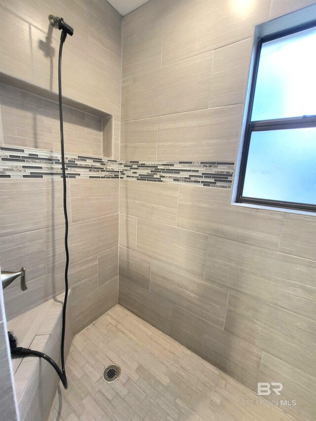 bathroom featuring plenty of natural light and a tile shower