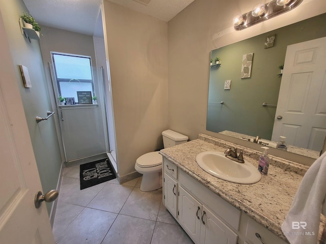 bathroom featuring tile patterned floors, vanity, toilet, and a shower with door