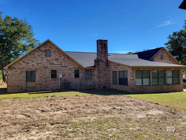 rear view of house with a yard and central AC