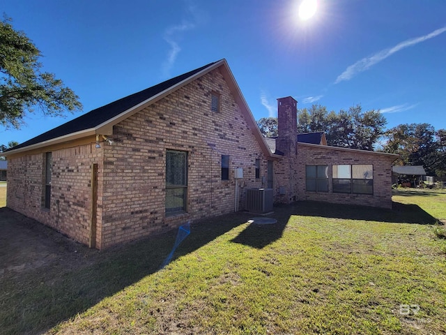 back of house with a lawn and central air condition unit