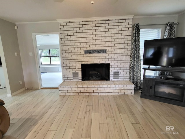 unfurnished living room featuring light hardwood / wood-style floors, crown molding, and a fireplace