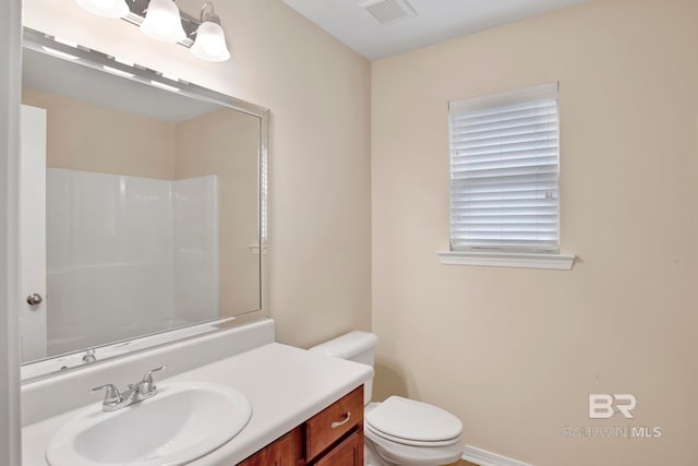 bathroom featuring vanity, toilet, and walk in shower