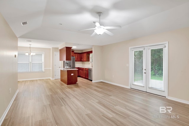 unfurnished living room featuring ceiling fan with notable chandelier, light hardwood / wood-style floors, vaulted ceiling, and french doors