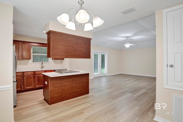 kitchen featuring french doors, sink, light hardwood / wood-style flooring, decorative light fixtures, and ceiling fan with notable chandelier