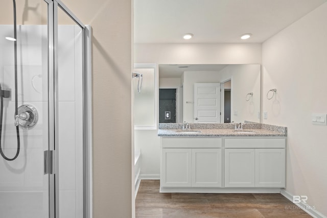 24193 Lanai Ln, Elberta, AL 36530 - bathroom with an enclosed shower, double vanity, wood finished floors, a bathtub, and recessed lighting