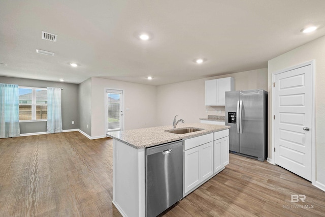 24193 Lanai Ln, Elberta, AL 36530 - kitchen featuring stainless steel appliances, light wood-style flooring, an island with sink, white cabinets, and recessed lighting