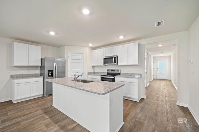 24193 Lanai Ln, Elberta, AL 36530 - kitchen with stainless steel appliances, a kitchen island with sink, white cabinetry, dark wood finished floors, and recessed lighting