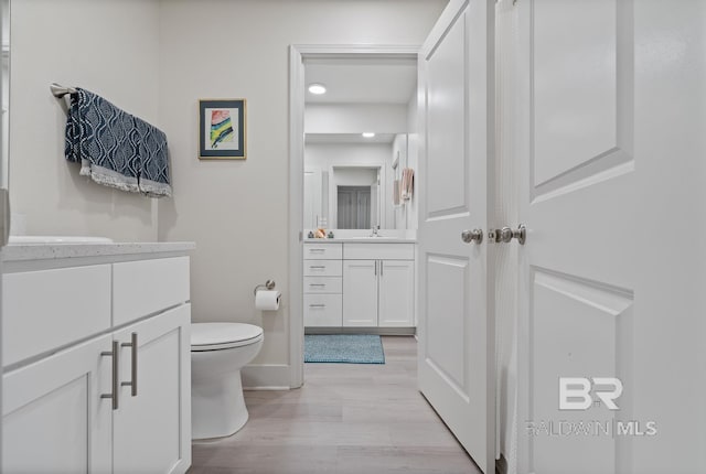 bathroom with vanity, wood-type flooring, and toilet