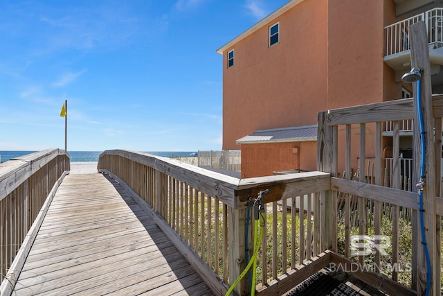 view of property's community with a water view and a beach view