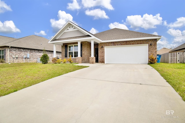 craftsman house with a front yard, an attached garage, and brick siding