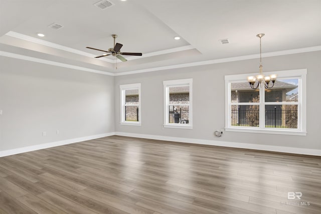 spare room featuring a tray ceiling, visible vents, and ceiling fan with notable chandelier